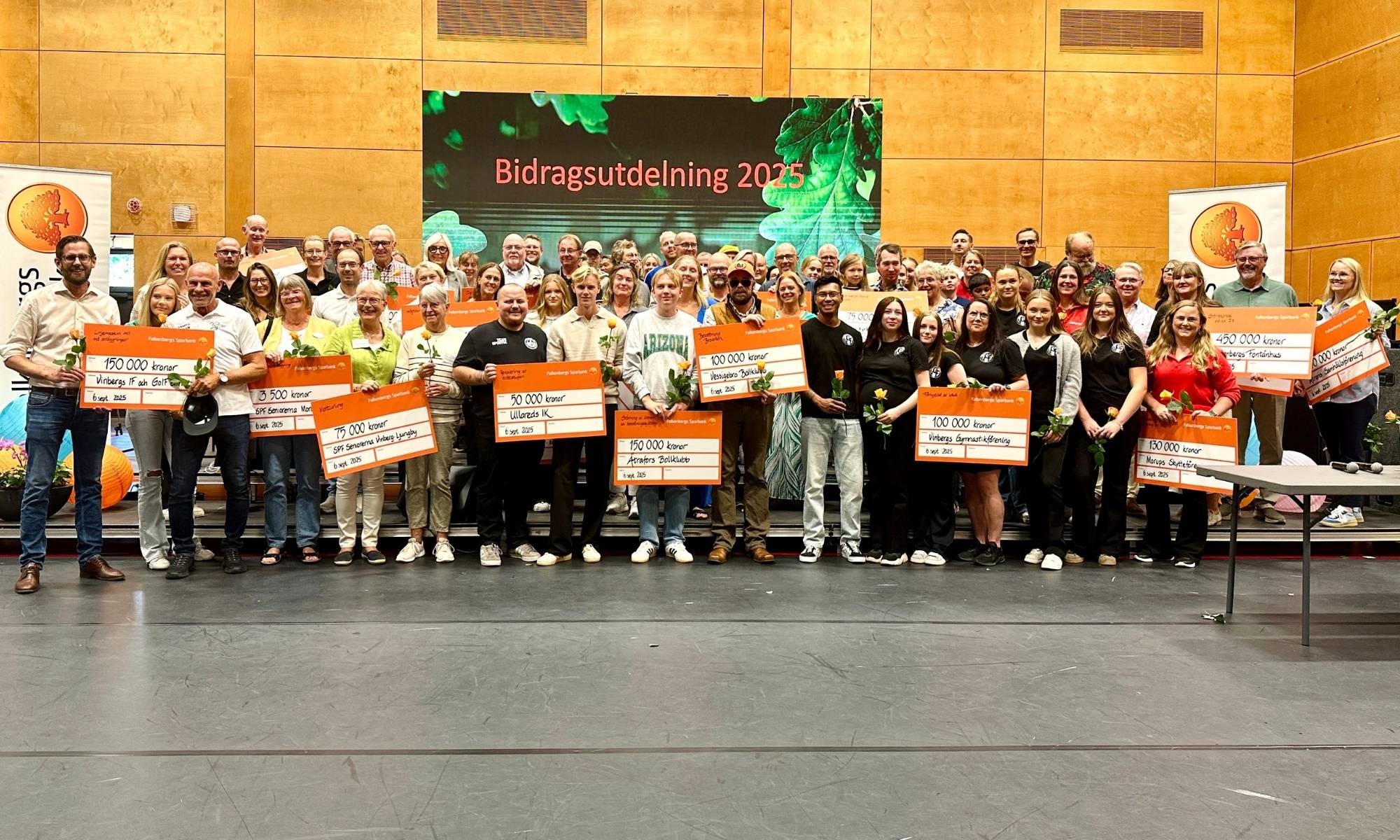 Gruppfoto av glada bidragstagare med stora checkar vid bidragsutdelning 2025.Gruppfoto av glada bidragstagare med stora checkar vid bidragsutdelning 2025.