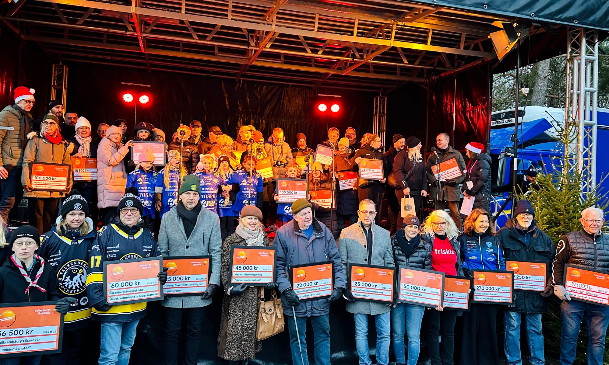 Mottagare av bidrag med checkar i händerna