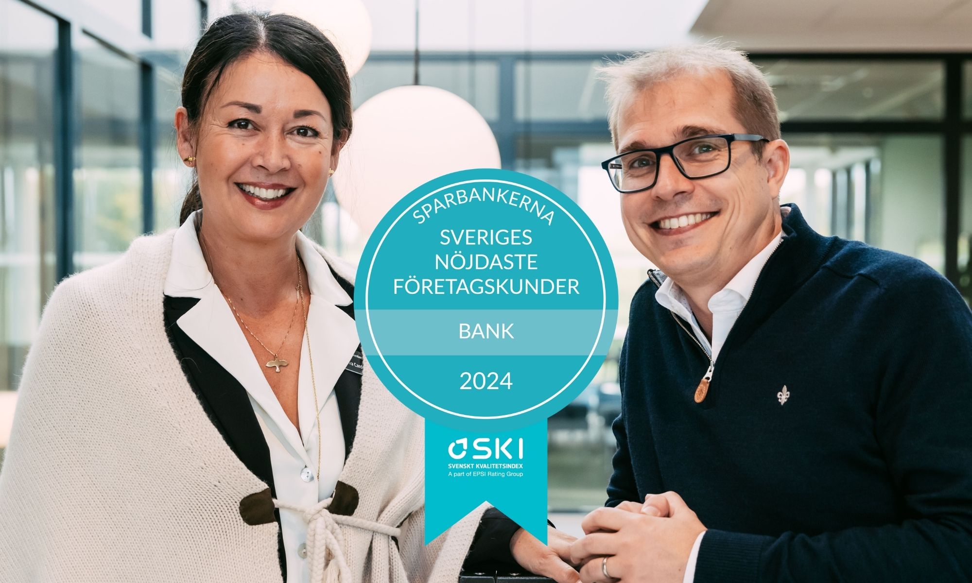 Två leende personer, en kvinna och en man, står bredvid varandra med en utmärkelse framför sig som lyder "Sparbankerna, Sveriges nöjdaste företagskunder, 2024."
