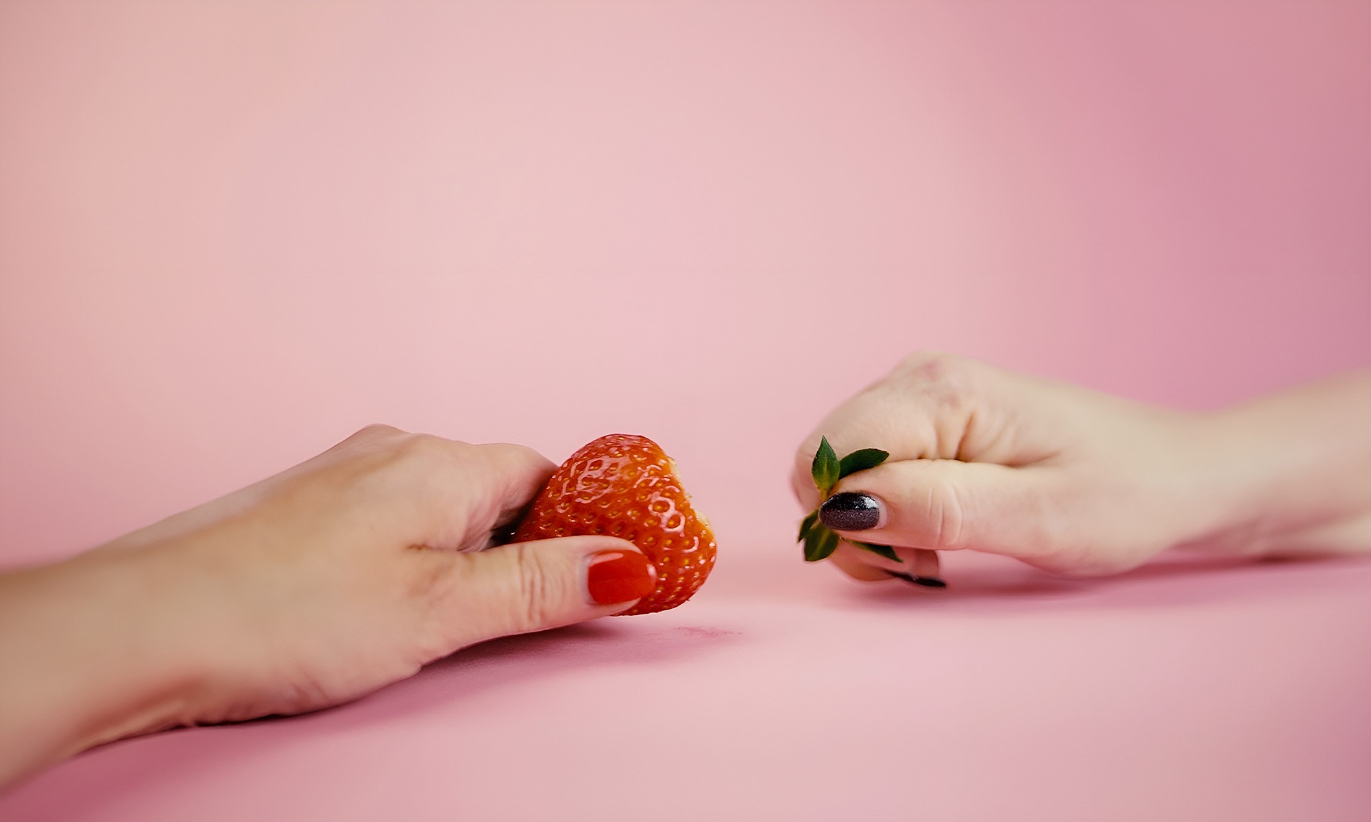 Hands that share a strawberry in two